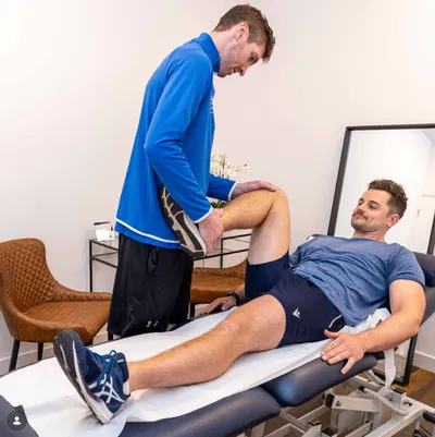 Peter performing a knee assessment on a client in the clinic